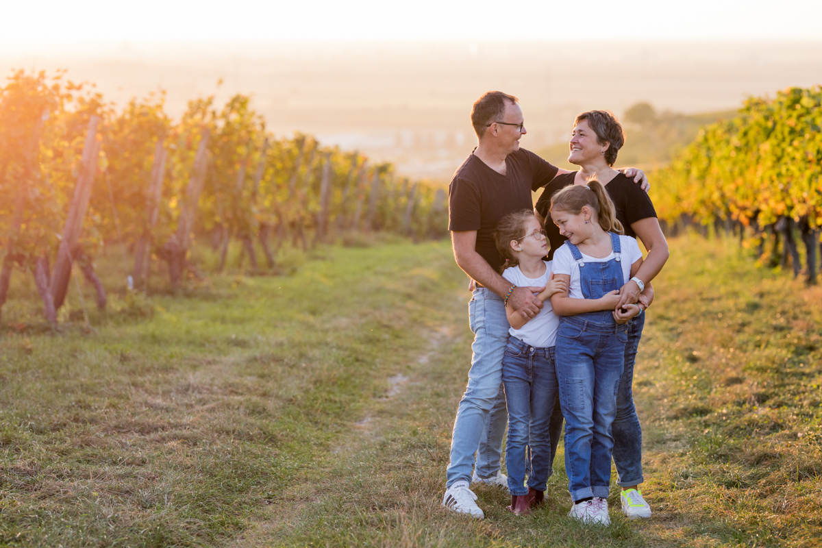Familie in den Reben bei Sonneuntergang 