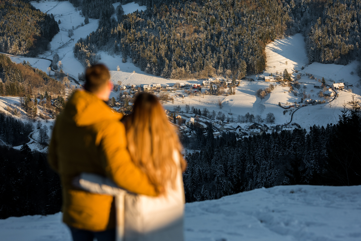Paar schaut in die Ferne beim Shooting im Schnee